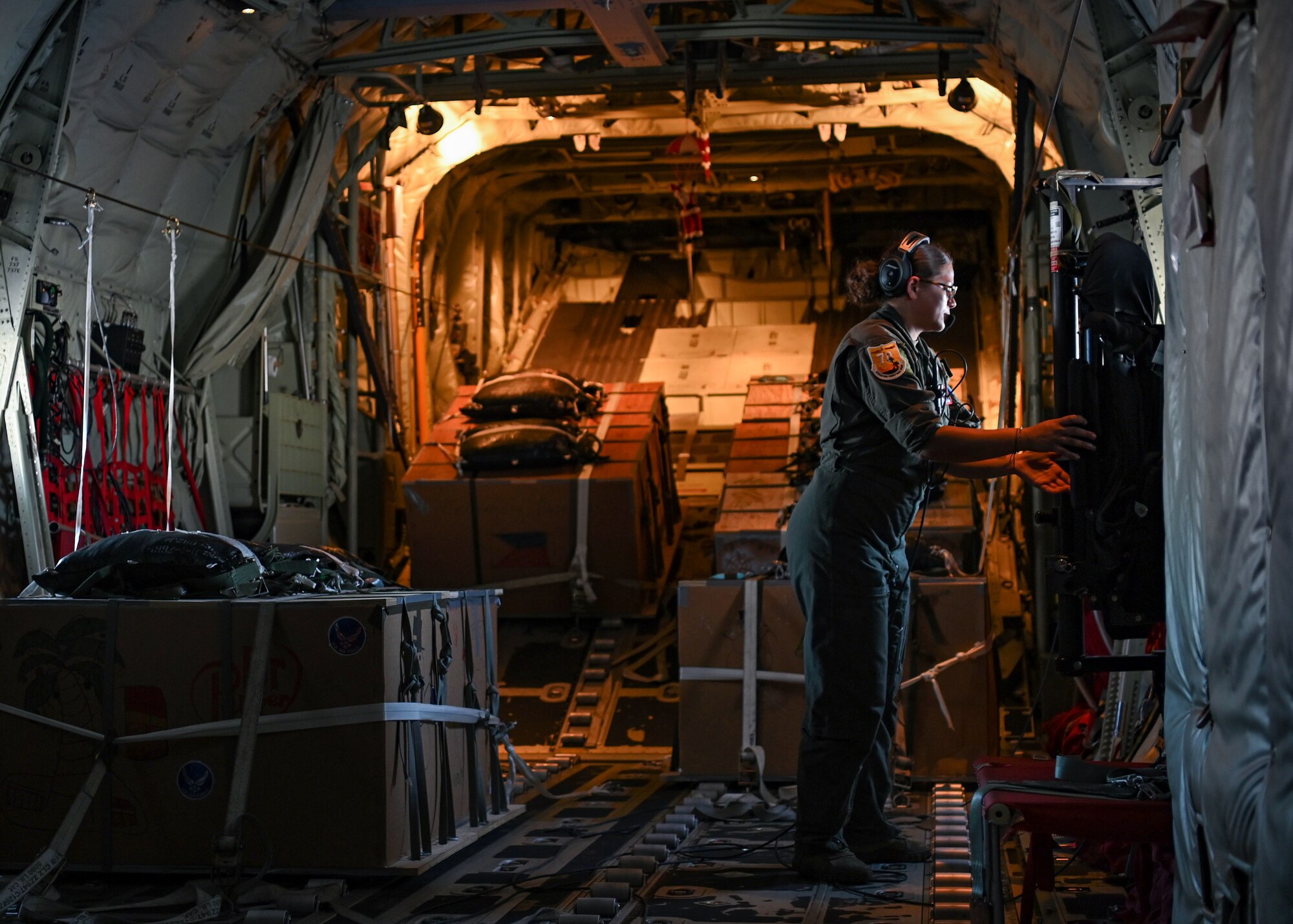 U.S. Air Force Senior Airman Kim Doyle, a loadmaster assigned to the 36th Airlift Squadron, Yokota Air Base, Japan, performs items off her in flight checklist on a U.S. Air Force C-130J during Operation Christmas Drop at Andersen Air Force Base, Guam, Dec. 10, 2021. Over the course of 10 days, crews will airdrop donated food, clothing, educational materials, and tools to 55 islanders throughout the South-Eastern Pacific, including the Federated States of Micronesia, and the Republic of Palau. (U.S. Air Force photo by Senior Airman Aubree Owens)