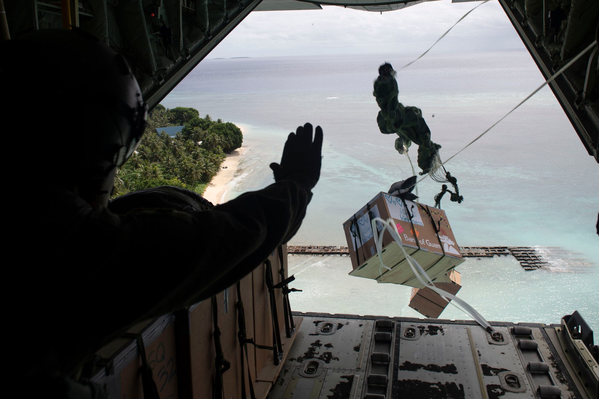 Col. Andrew Campbell, 374th Airlift Wing commander, waves after pushing out bundles during the 70th Anniversary of Operation Christmas Drop near Asor, Dec. 5, 2021. OCD is the Department of Defense’s longest-running humanitarian aid and disaster relief training mission and provides relief to more than 55 islands throughout the Pacific. Operations such as OCD provide the U.S. and its partners the opportunity to enhance joint operational capabilities and maintain preparedness for real-world emergencies. (U.S. Air Force photo by Tech. Sgt. Joshua Edwards)