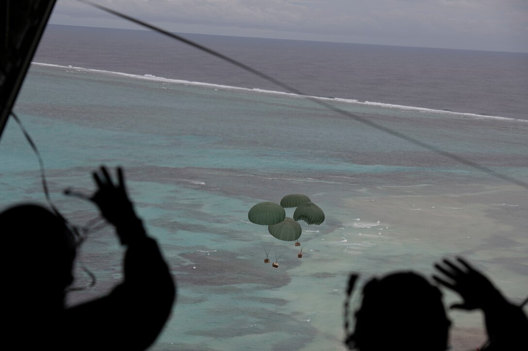 Lt. Gen. Ricky Rupp, U.S. Forces Japan and 5th Air Force commander, left, and Chief Master Sgt. Jerry Dunn, 374th Airlift Wing command chief, wave after pushing bundles from a C-130J Super Hercules during the 70th Anniversary of Operation Christmas Drop at near Kuttu Island, Dec. 6, 2021. OCD is the Department of Defense’s longest-running humanitarian aid and disaster relief training mission and provides relief to more than 55 islands throughout the Pacific. Operations such as OCD provide the U.S. and its partners the opportunity to enhance joint operational capabilities and maintain preparedness for real-world emergencies. (U.S. Air Force photo by Tech. Sgt. Joshua Edwards)