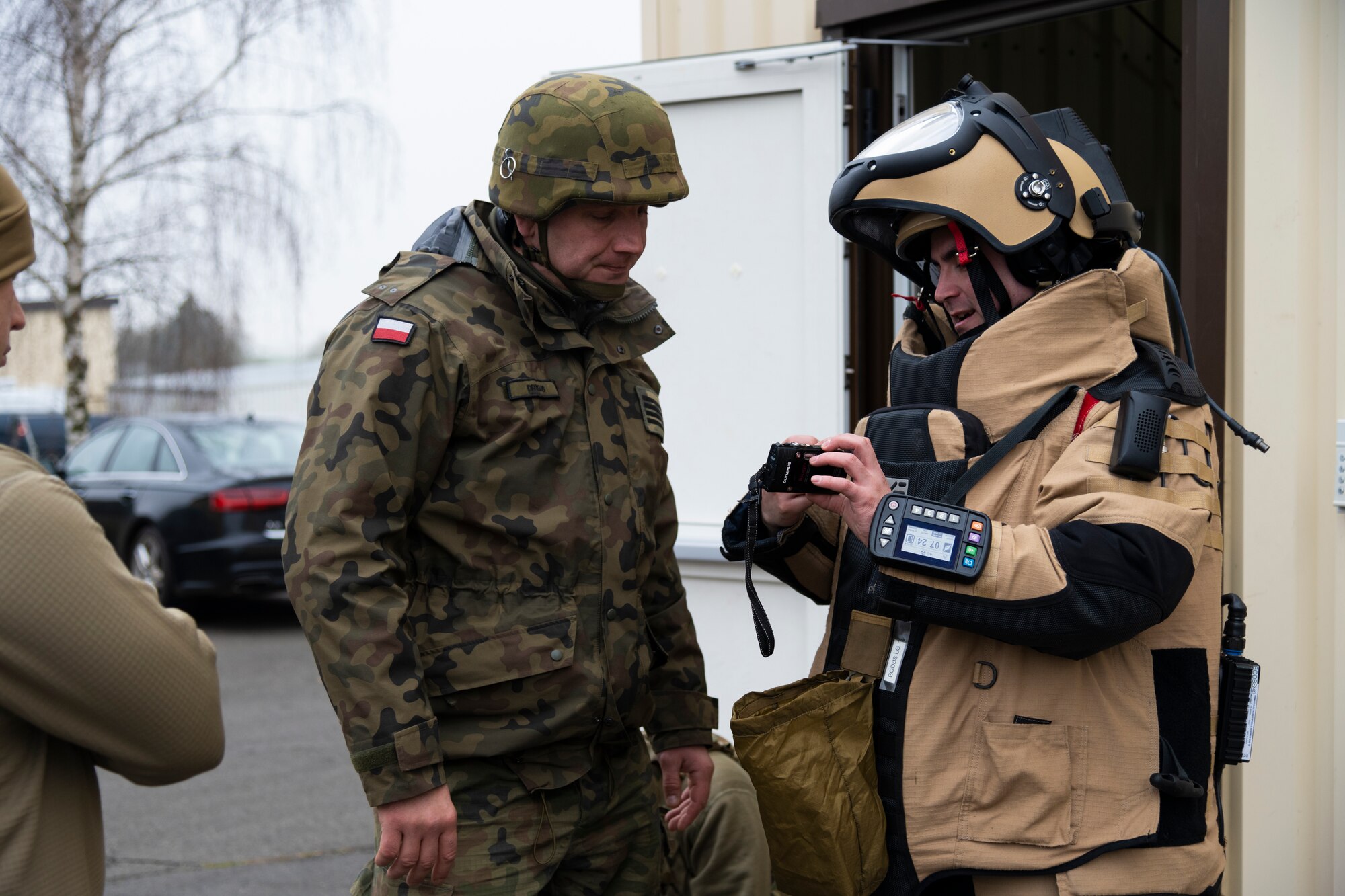 A U.S. Air Force Explosive Ordnance Disposal technician, assigned to the 52nd Fighter Wing Civil Engineer Squadron,  discusses a tactical plan with a Polish Improvised Explosive Device unit member during the ongoing familiarization and interoperability training at Spangdahlem Air Base, Dec. 9, 2021.