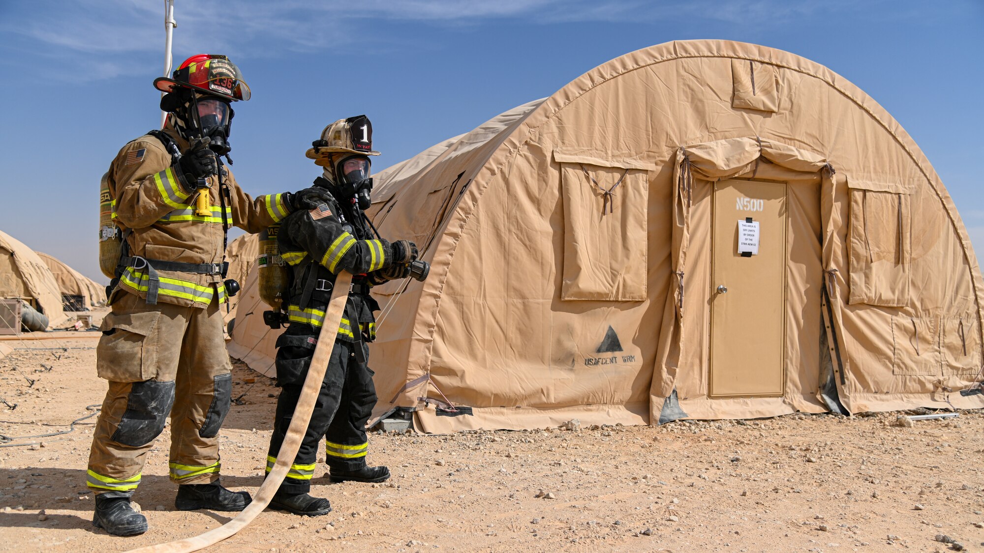 U.S. Air Force Staff Sgt. Sanjar Tursunov, left, 378th Expeditionary Civil Engineer Squadron firefighter, and Brig. Gen. Robert Davis, right, 378th Air Expeditionary Wing commander, prepare to extinguish a simulated structure fire at Prince Sultan Air Base, Kingdom of Saudi Arabia, Dec. 9, 2021. Davis spent the day training alongside members of the fire department during an immersion tour with the 378th ECES. (U.S. Air Force photo by Staff Sgt. Christina Graves)