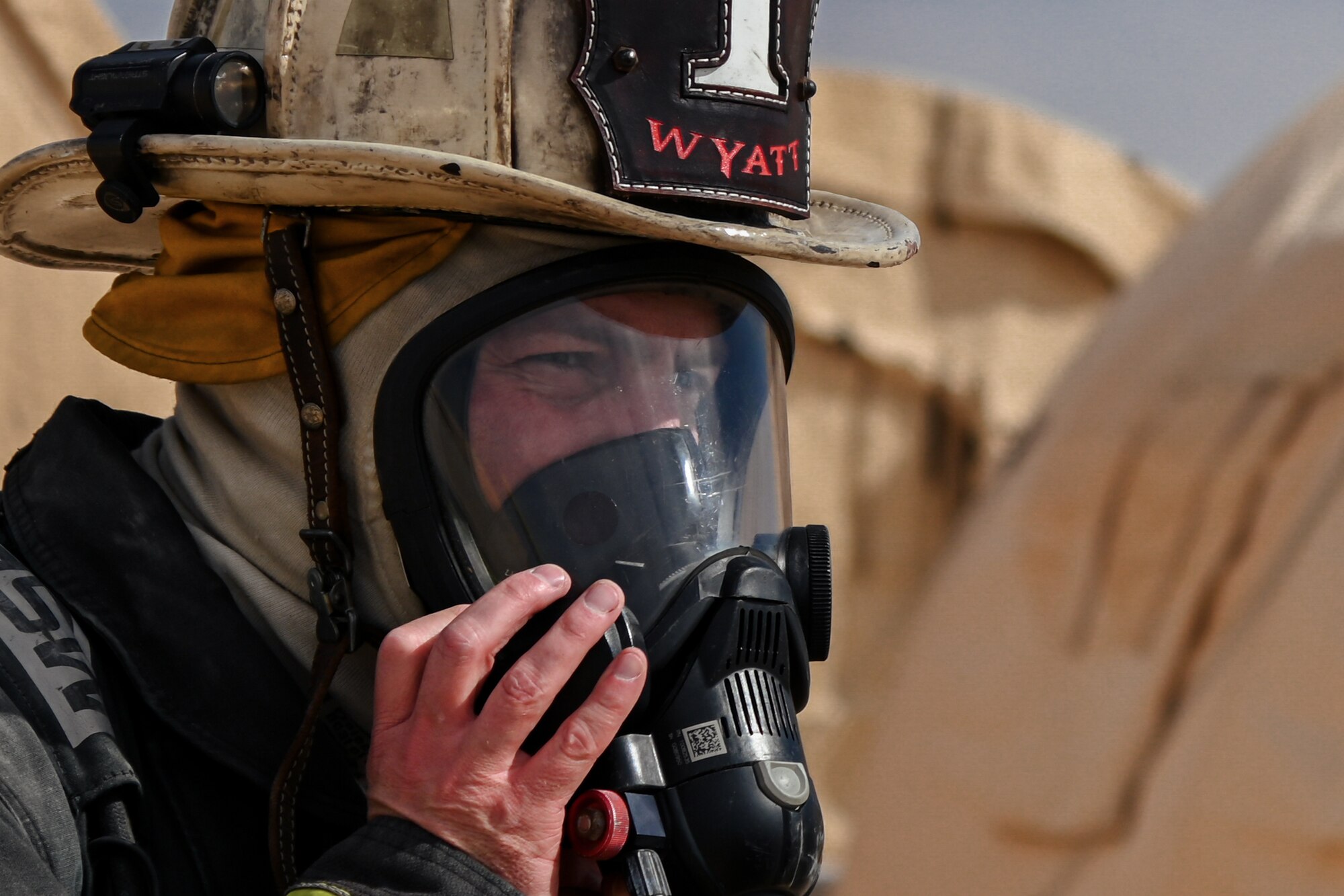 U.S. Air Force Brig. Gen. Robert Davis, 378th Air Expeditionary Wing commander, removes his helmet after training alongside firefighters from the 378th Expeditionary Civil Engineer Squadron at Prince Sultan Air Base, Kingdom of Saudi Arabia, Dec. 9, 2021. Davis spent the day training alongside members of the fire department during an immersion tour with the 378th ECES. (U.S. Air Force photo by Staff Sgt. Christina Graves)