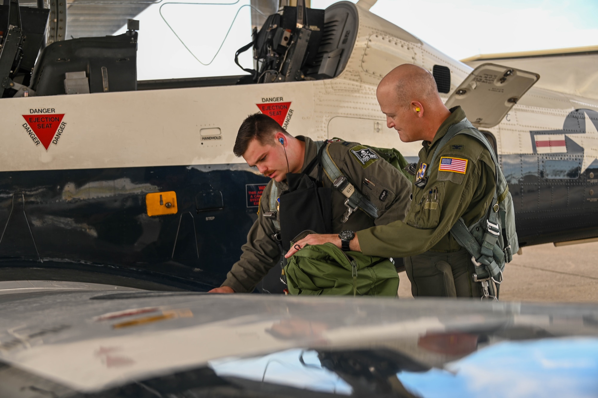 U.S. Air Force Col. Blaine Baker, commander of the 97th Air Mobility Wing at Altus Air Force Base (AFB), Oklahoma, and Capt. Jay Kalson, instructor pilot in the 434th Flying Training Squadron at Laughlin AFB, Texas, read flight plans before takeoff at Laughlin AFB, Dec. 10, 2021. Baker received part of his pilot training at Laughlin AFB in 2005. (U.S. Air Force photo by Airman 1st Class Kayla Christenson)