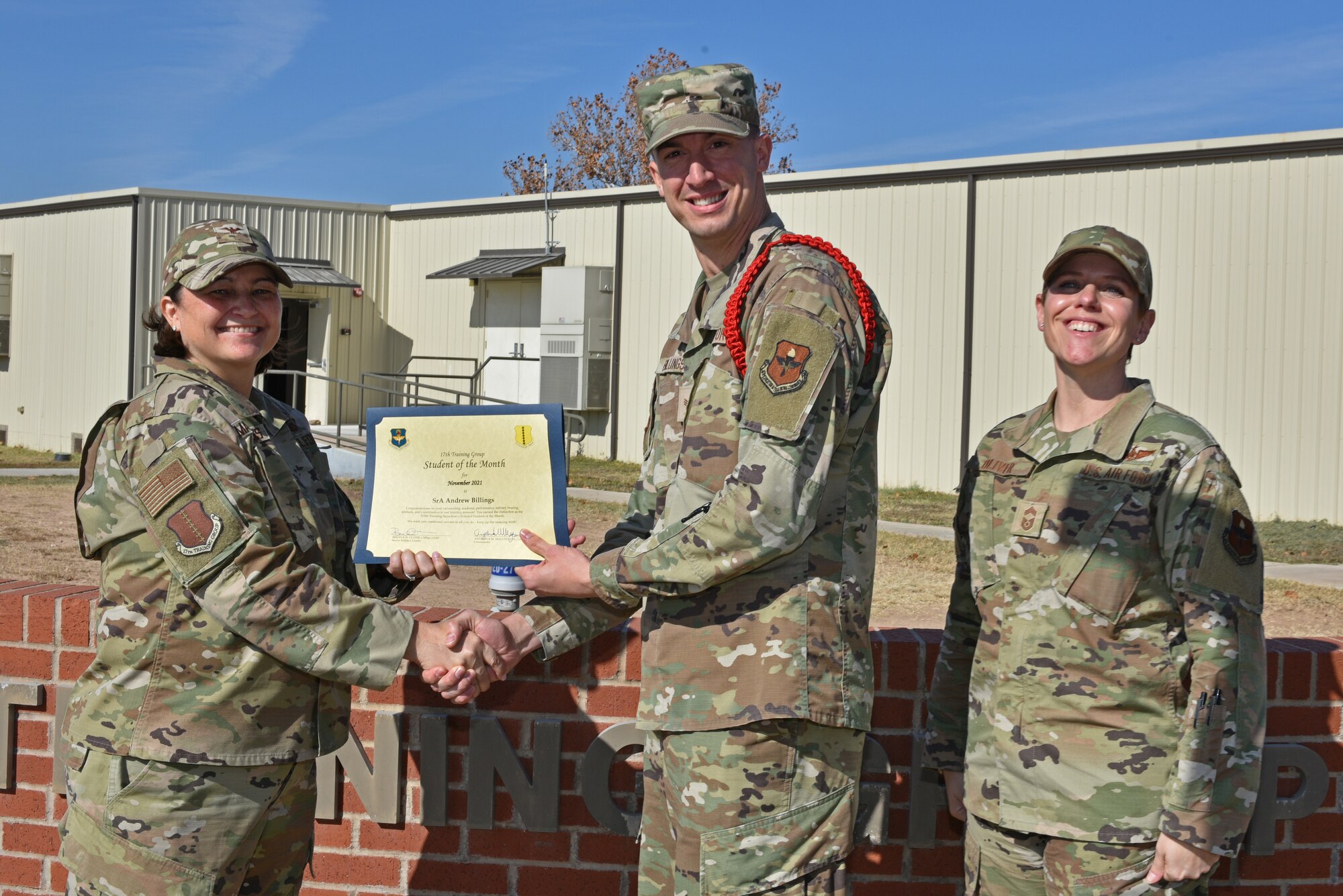 U.S. Air Force Col. Angelina Maguinness, 17th Training Group commander, and Chief Master Sgt. Breana Oliver, 17th TRG superintendent, present Senior Airman Andrew Billings, 315th Training Squadron student, the 315th TRS Student of the Month award for November 2021, on Goodfellow Air Force Base, Texas, Dec. 14, 2021. Billings was recognized for his hard work and dedication. (U.S. Air Force photo by Senior Airman Ashley Thrash)