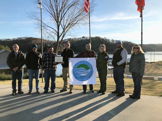 Environmental Protection Specialist Phillip Harrell, Realty Specialist Duane Bryson, Willow Grove Marina Manager Michael Maxwell, Willow Grove Marina employee Blake Ledbetter, Willow Grove Marina owner Mickey Ledbetter, Dale Hollow Lake Park Ranger Sondra Carmen, Biologist Daniel Clark, and Realty Specialist Lori Neubert pose proudly with the Clean Marina flag Nov. 29, 2021 to celebrate Willow Grove Marina’s recertification in the Clean Marina Program at Dale Hollow Lake in Celina, Tennessee.