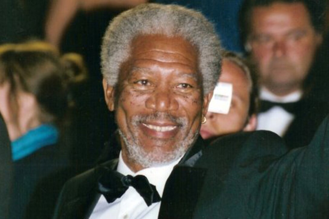 A man in a tuxedo poses for a photo.