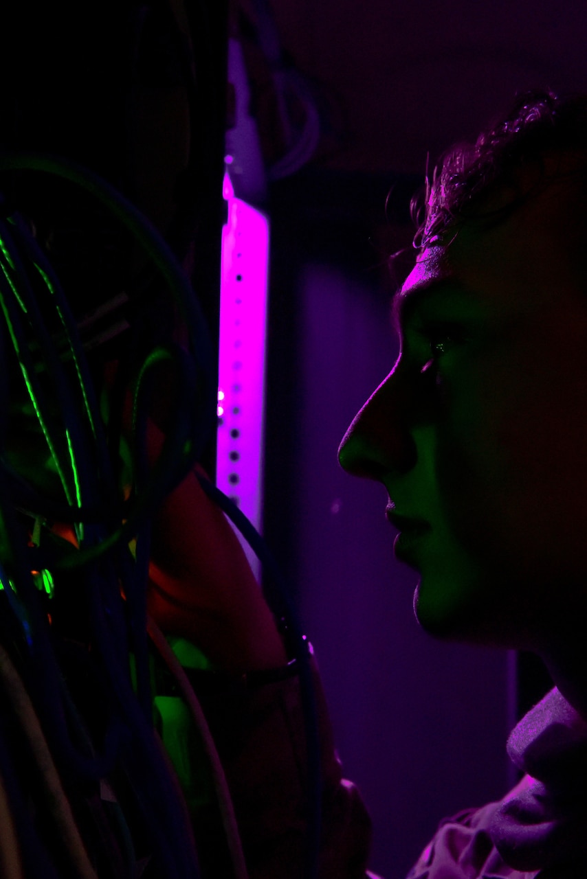 A man looks at a board with cables and wires.