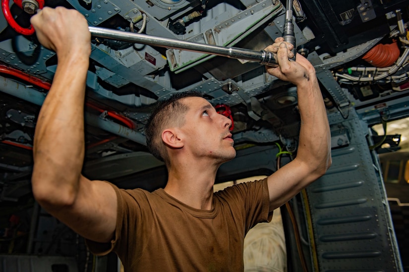 A sailor performs maintenance.