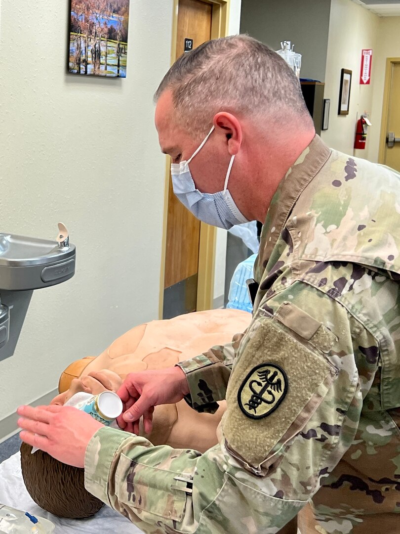 Maj. Mike Stevens, optometrist, Bayne-Jones Army Community Hospital demonstrates treating an eye trauma during the area of concentration, individual critical task list skills fair Dec. 13 at the Joint Readiness Training Center and Fort Polk, Louisiana.