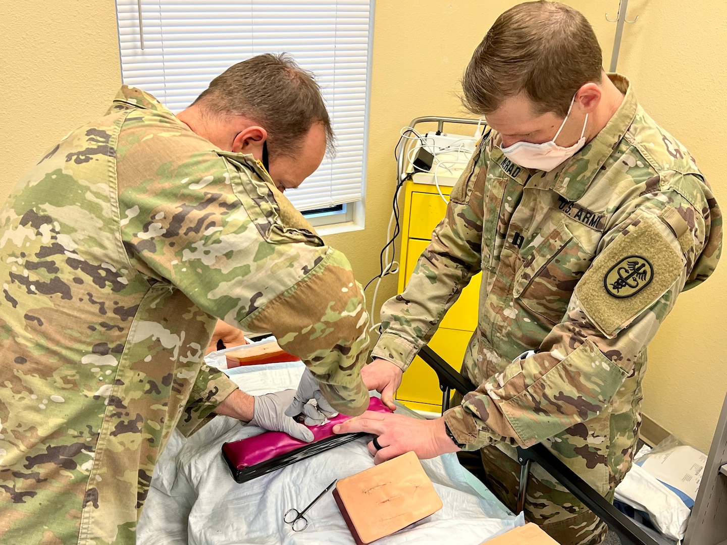 Capt. Dane Nerad, emergency medicine physician, Bayne-Jones Army Community Hospital, teaches 1st Lt. Steven Reed, battalion physician assistant, 2nd Battalion, 30th Infantry Regiment, 3rd Brigade Combat Team, 10th Mountain Division how to treat an abscess and cysts during the area of concentration, individual critical task list skills fair Dec. 13 at the Joint Readiness Training Center and Fort Polk, Louisiana.