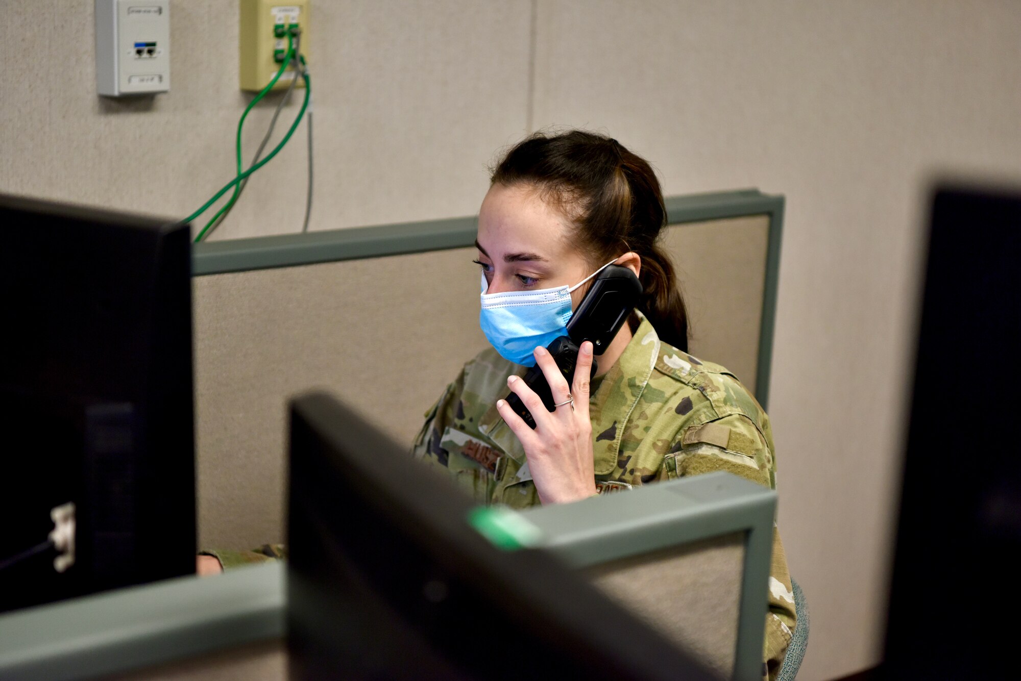 Senior Airman Esther Huszar, Joint Base Pearl Harbor-Hickam Emergency Operations Center phone operator technician, collects information from a caller to input into a database at Joint Base Pearl Harbor-Hickam, Hawaii, Dec. 14, 2021. The EOC is operated by a joint-military team, working 24/7, for the duration of the water issues. (U.S. Air Force photo by 1st Lt. Benjamin Aronson)