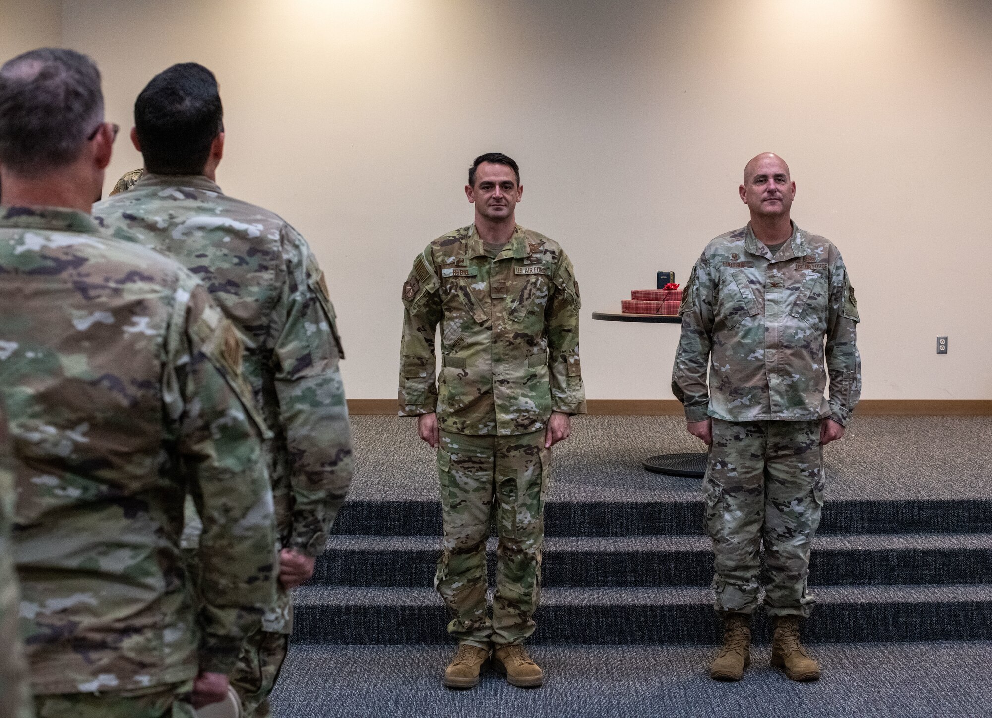 Airmen to the side stand facing forward as Rubio and Fortson stand at attention facing the camera