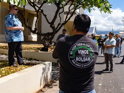 Jason Hence, left, presents the bonsai tree memorial to Code 130 Quality Assurance Branch at Bldg. 1443, Marshall Silva, Inspector at Code 135 wears a memorial t-shirt in the foreground. (U.S. Navy photo by Dave Amodo released)