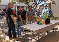 The Kapoi family takes a close-up look at the memorial bonsai tree by Jason Hence. From left to right, Ason Abe - Code 139, Fallyn Kapoi - Code 139, Vernon Kapoi – Shop 38, Vince Kapoi, Sr. – Code 970, Jason Hence, NAVSEA Nondestructive Testing and Welding Programs Manager. (U.S. Navy photo by Dave Amodo released)