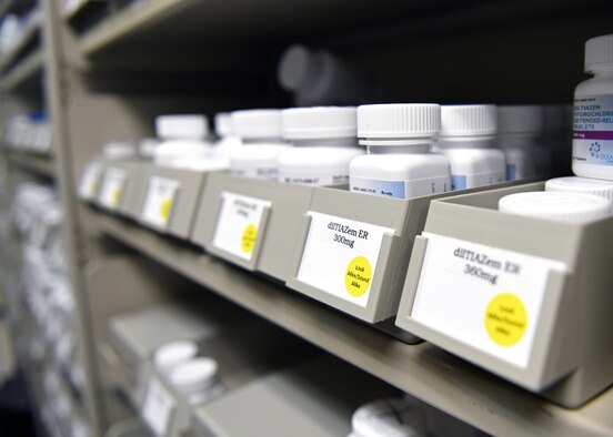 Prescription pill bottles sit on a shelf