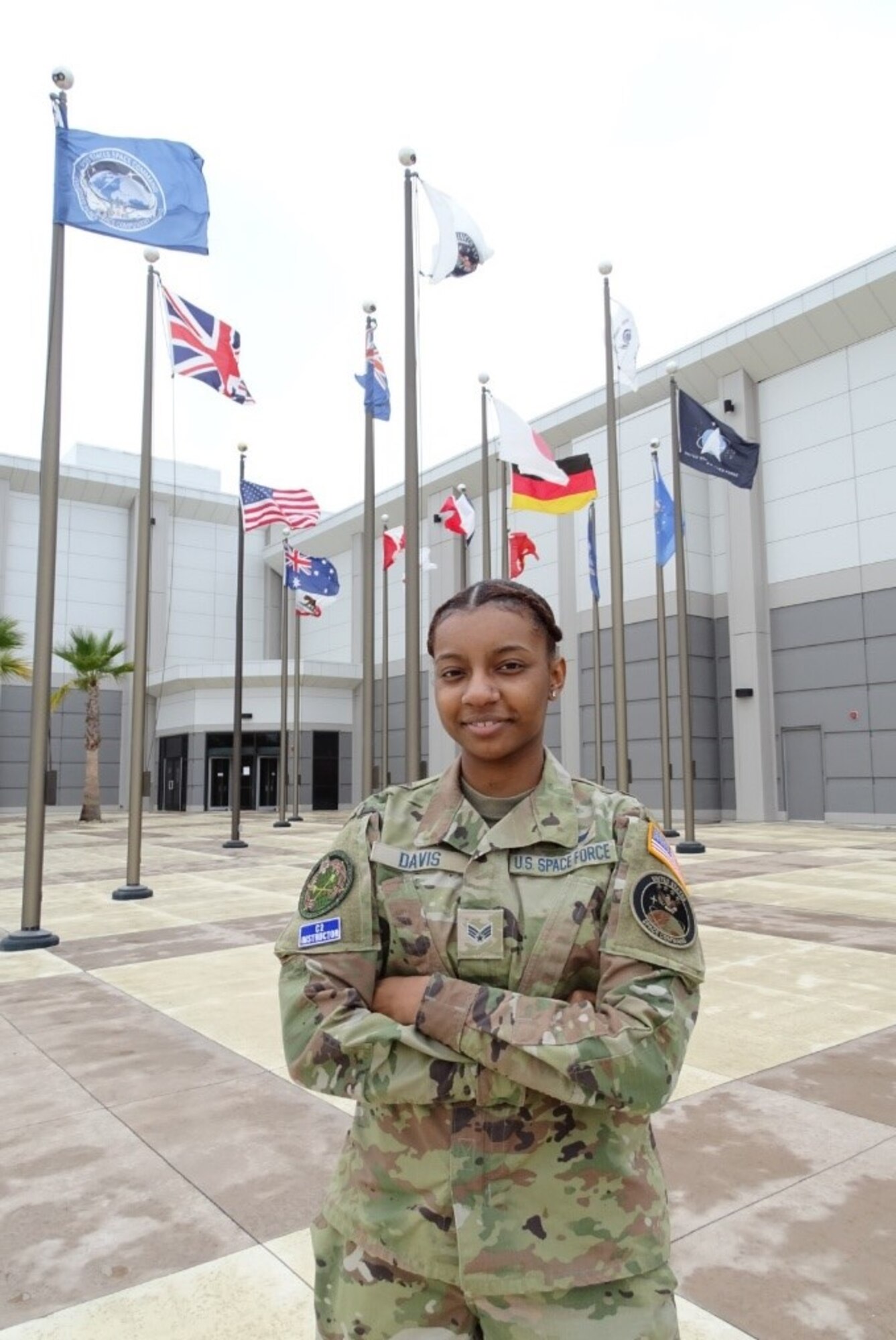 Specialist 4 Quineaja Davis stands for a photo in front of the Combined Force Space Component Command headquarters building Dec. 13, 2021, at Vandenberg Space Force Base, Calif. An Electromagnetic Duty Operator working at the Combined Space Operations Center, Davis and her team maintain DoD satellite communication links for warfighters across the globe, 24-hours a day, seven days a week.  (U.S. Space Force photo by Lt. Col. Mae-Li Allison)