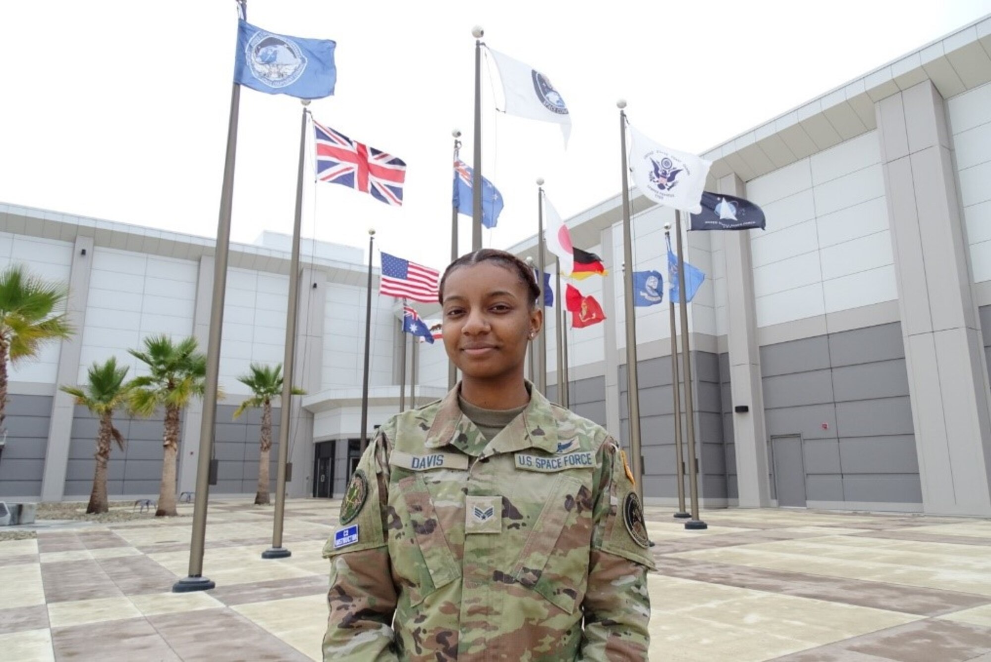 Specialist 4 Quineaja Davis stands for a photo in front of the Combined Force Space Component Command headquarters building Dec. 13, 2021, at Vandenberg Space Force Base, Calif. An Electromagnetic Duty Operator working at the Combined Space Operations Center, Davis recently won the CFSCC third quarter award in the junior enlisted category, in part because she helped in the effort to monitor secure U.S. Space Command and commercial satellite communication links during the emergency airlift operation at Kabul Airport, ensuring the evacuation of more than 124,000 U.S. citizens and multi-national refugees from Afghanistan. (U.S. Space Force photo by Lt. Col. Mae-Li Allison)