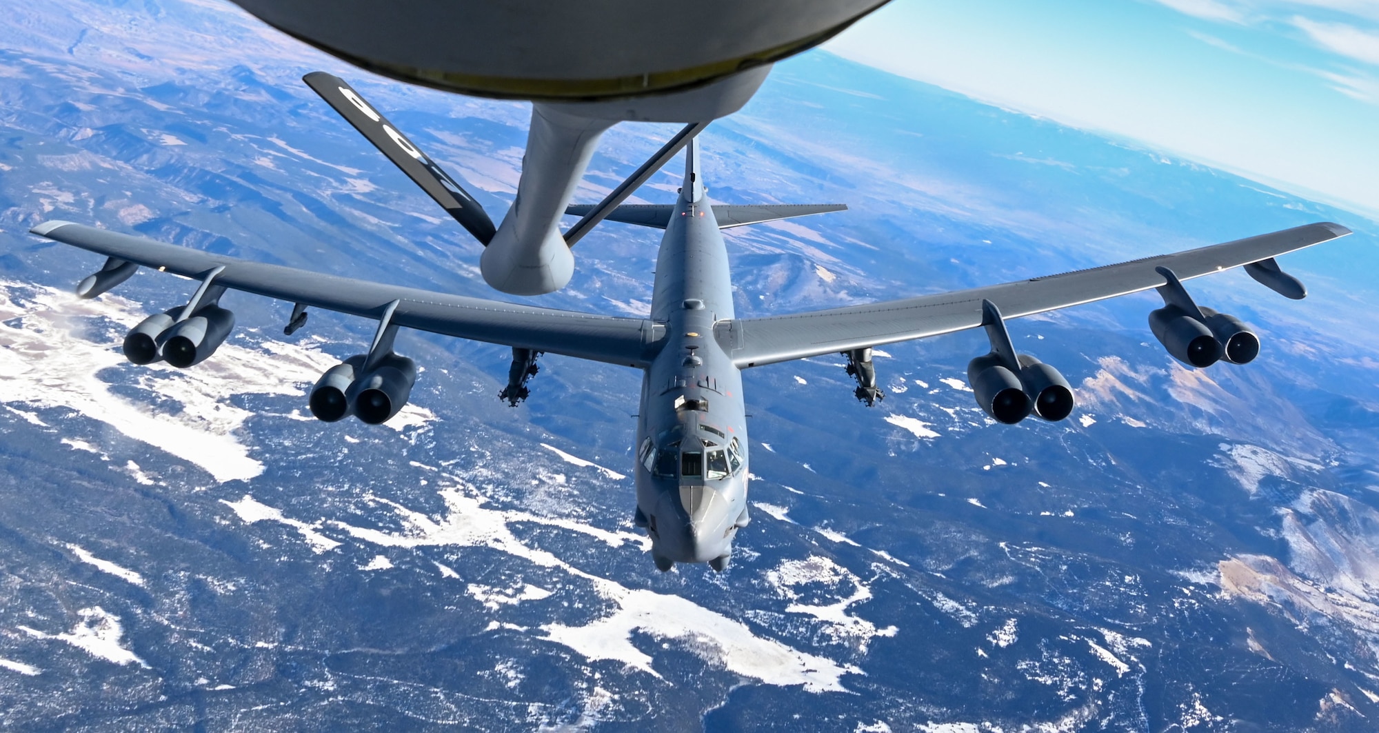 A B-52 Stratofortress assigned to the 96th Bomb Squadron Barksdale Air Force Base, Louisiana, prepares to refuel with a KC-135 Stratotanker assigned to the 465th Air Refueling Squadron, Tinker AFB, Oklahoma, above the Rocky Mountains, Dec. 13, 2021. Aerial refueling allows aircraft to travel vast distances without landing to bring airpower anytime, anywhere around the world. (U.S. Air Force photo by 2nd Lt. Mary Begy)