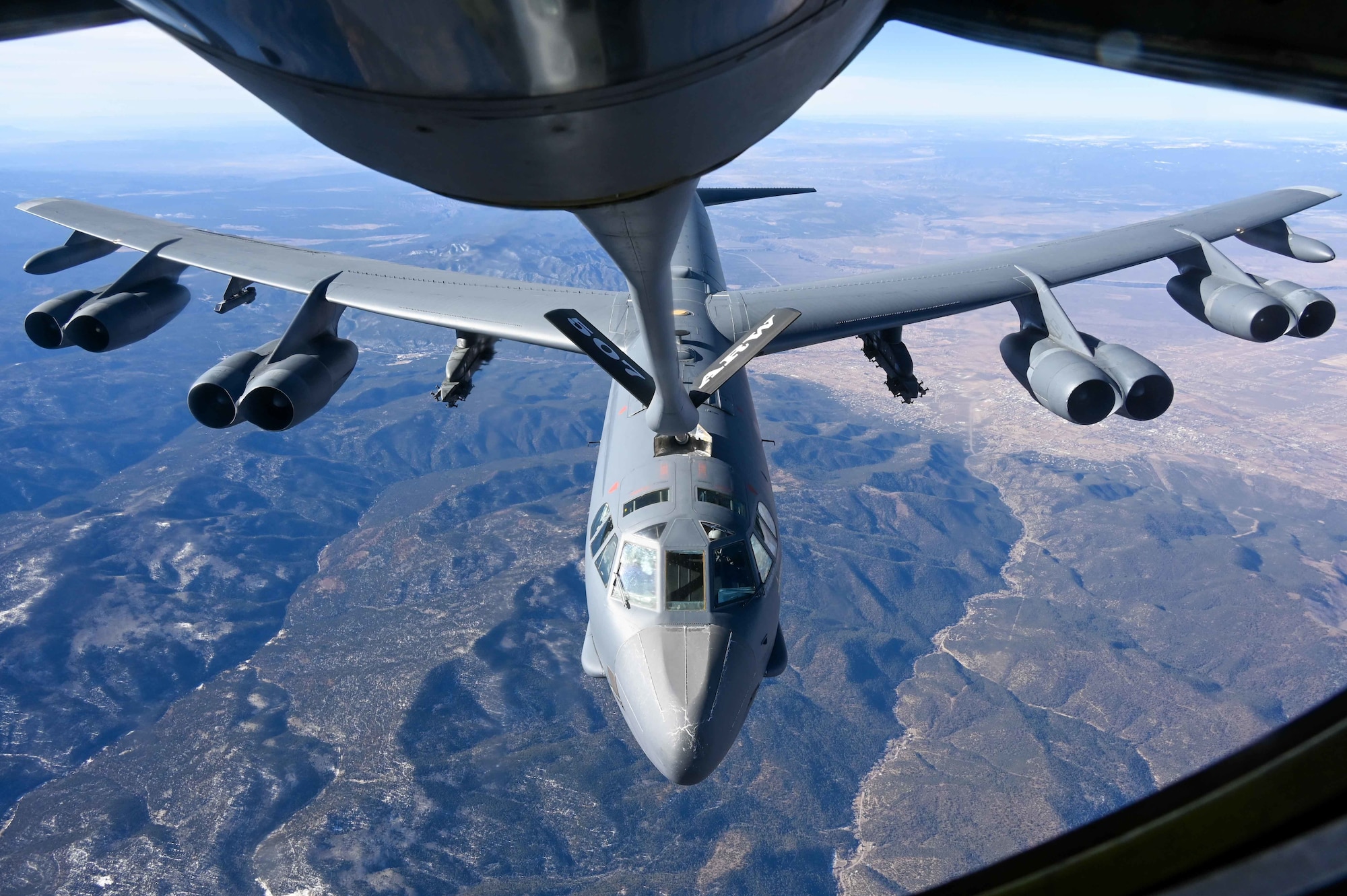 A B-52 Stratofortress assigned to the 96th Bomb Squadron Barksdale Air Force Base, Louisiana, refuels with a KC-135 Stratotanker assigned to the 465th Air Refueling Squadron, Tinker AFB, Oklahoma, above the Rocky Mountains, Dec. 13, 2021. Aerial refueling allows aircraft to travel vast distances without landing to bring airpower anytime, anywhere around the world. (U.S. Air Force photo by 2nd Lt. Mary Begy)