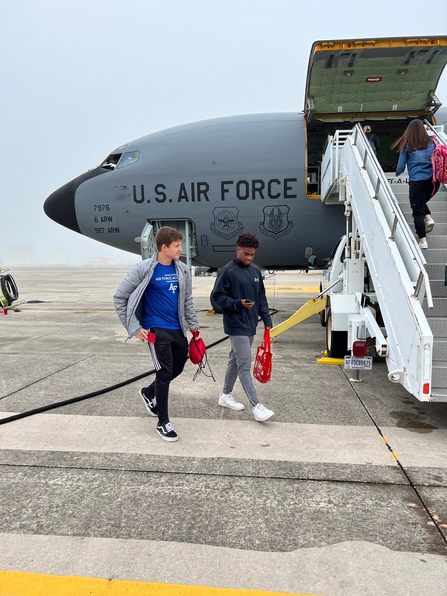 Jacob Ellis, a senior at Hillsborough High School and Khari Anglin, a senior at Newsome High School, prepare to board a KC-135 Stratotanker aircraft Dec. 9, 2021, at MacDill Air Force Base, Florida.