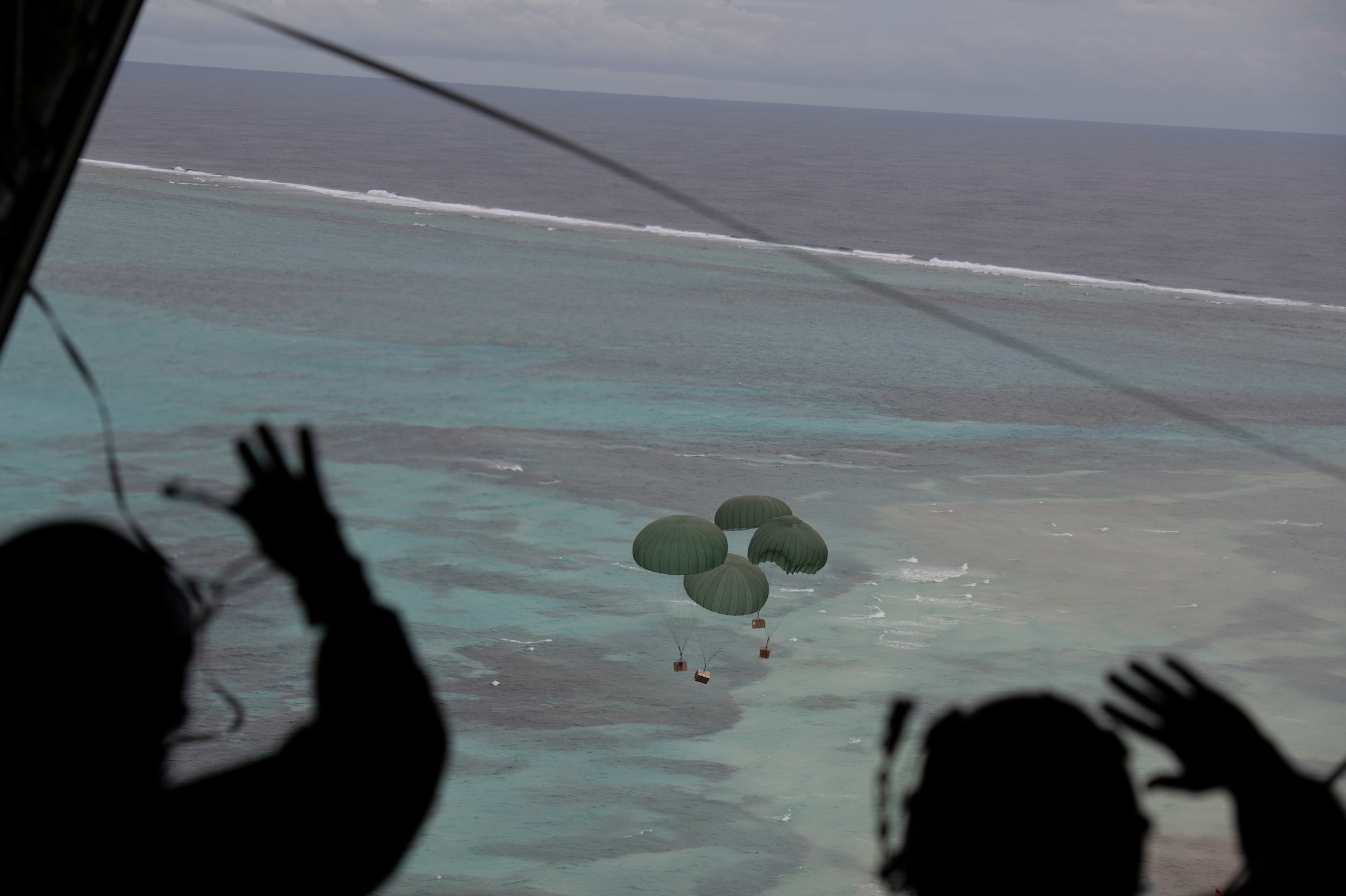 Lt. Gen. Ricky Rupp, U.S. Forces Japan and 5th Air Force commander, left, and Chief Master Sgt. Jerry Dunn, 374th Airlift Wing command chief, wave after pushing bundles from a C-130J Super Hercules during the 70th Anniversary of Operation Christmas Drop at near Kuttu Island, Dec. 6, 2021. OCD is the Department of Defense’s longest-running humanitarian aid and disaster relief training mission and provides relief to more than 55 islands throughout the Pacific. Operations such as OCD provide the U.S. and its partners the opportunity to enhance joint operational capabilities and maintain preparedness for real-world emergencies. (U.S. Air Force photo by Tech. Sgt. Joshua Edwards)