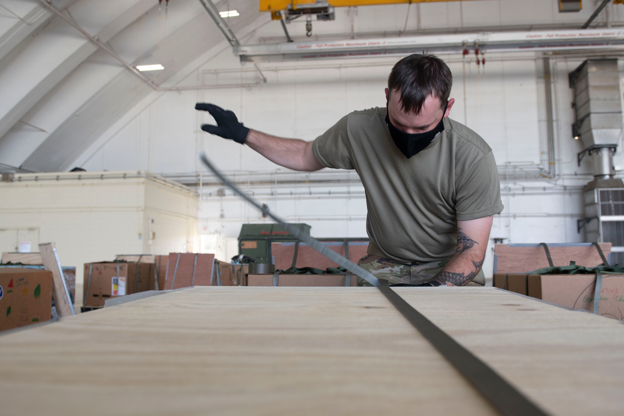 Airman 1st Class Shawn Fuller, 374th Logistics Readiness Squadron combat mobility flight technician, prepares a bundle during the 70th Anniversary of Operation Christmas Drop at Andersen Air Force Base, Guam, Dec. 8, 2021. OCD is the Department of Defense’s longest-running humanitarian aid and disaster relief training mission and provides relief to more than 55 islands throughout the Pacific. Operations such as OCD provide the U.S. and its partners the opportunity to enhance joint operational capabilities and maintain preparedness for real-world emergencies. (U.S. Air Force photo by Tech. Sgt. Joshua Edwards)