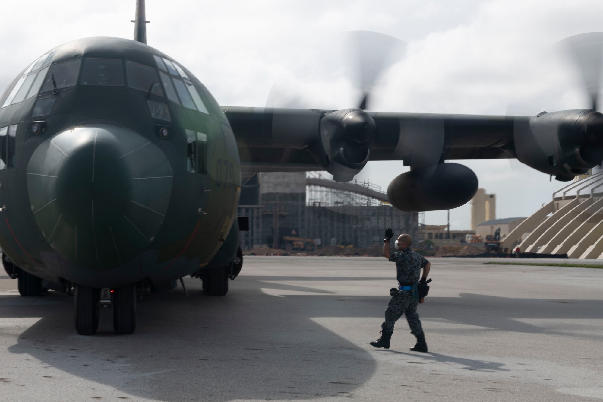 A member of the Japan Air Self-Defense Force (Koku-Jieitai) signals to a JASDF pilot during the 70th Anniversary of Operation Christmas Drop at Andersen Air Force Base, Guam, Dec. 5, 2021. OCD is the Department of Defense’s longest-running humanitarian aid and disaster relief training mission and provides relief to more than 55 islands throughout the Pacific. Operations such as OCD provide the U.S. and its partners the opportunity to enhance joint operational capabilities and maintain preparedness for real-world emergencies. (U.S. Air Force photo by Tech. Sgt. Joshua Edwards)