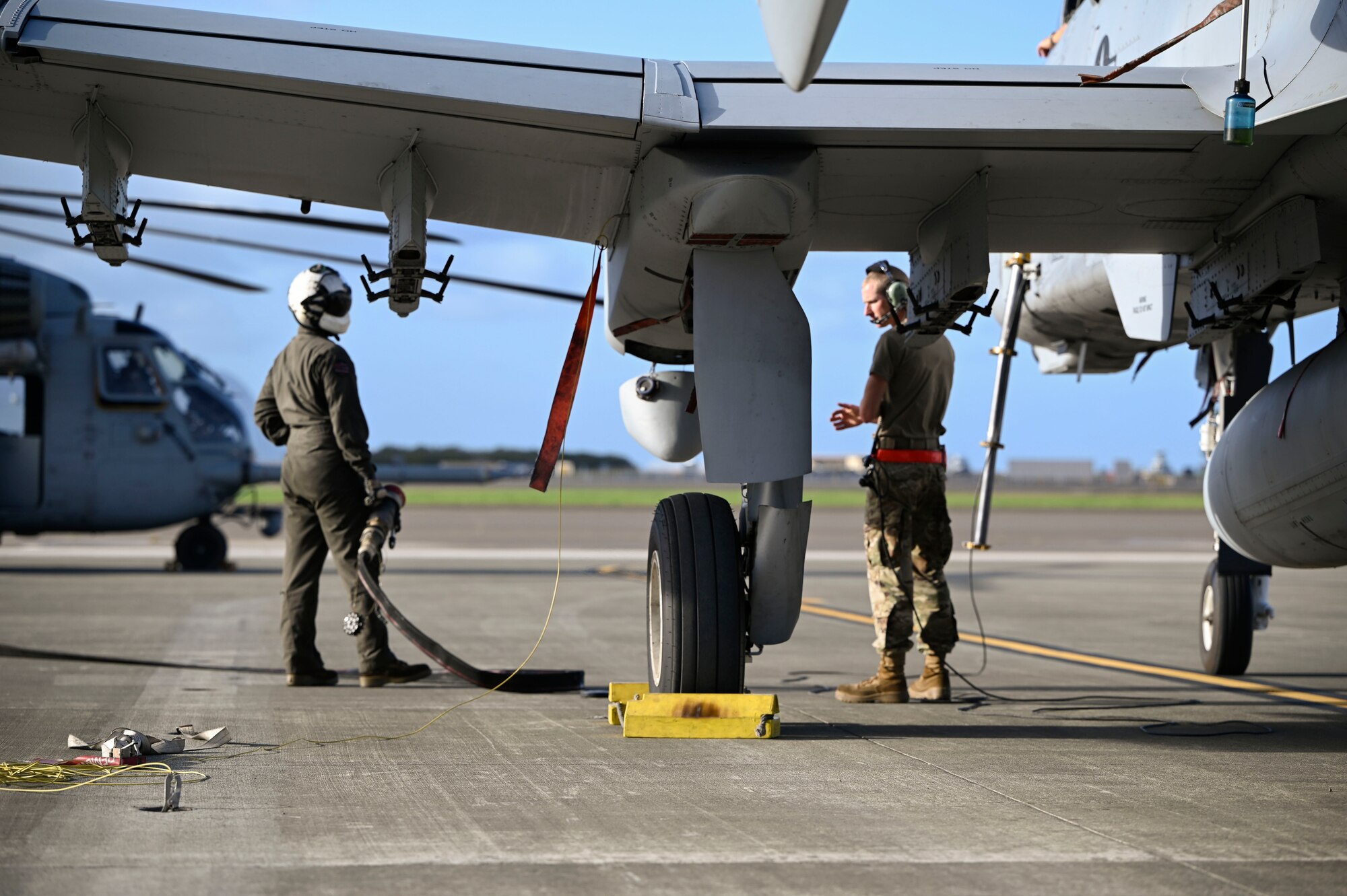 A U.S. Marine Corps Forward Area Refueling Point team practices aviation-delivered ground refueling (ADGR) from a CH-53 to A-10s during Exercise KANI WILDCAT. ADGR is frequently used for aircraft when unable to refuel in flight and/or to keep the aircraft closer to the fight.