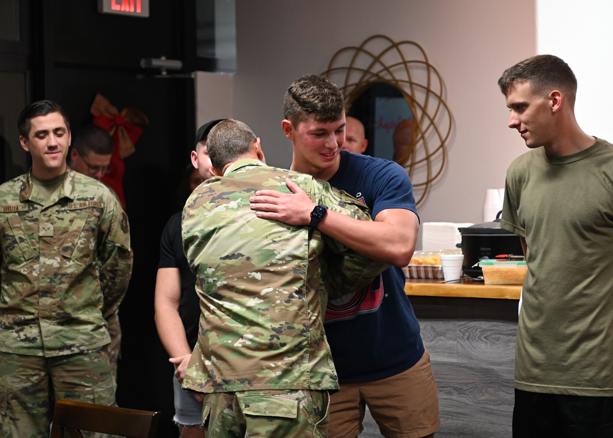 U.S. Air Force Maj. Kelvin Francis, a chaplain at the 36th Wing, hugs an Airman who helped remodel an Airmen’s Center at Chapel 1 during the opening ceremony at Andersen Air Force Base, Guam, Dec. 15, 2021. Members from the chapel team and dorm residents worked for months reconstructing an empty space to operationalize a piece of the chapel to be Airmen focused. (U.S. Air Force photo by Senior Airman Aubree Owens)