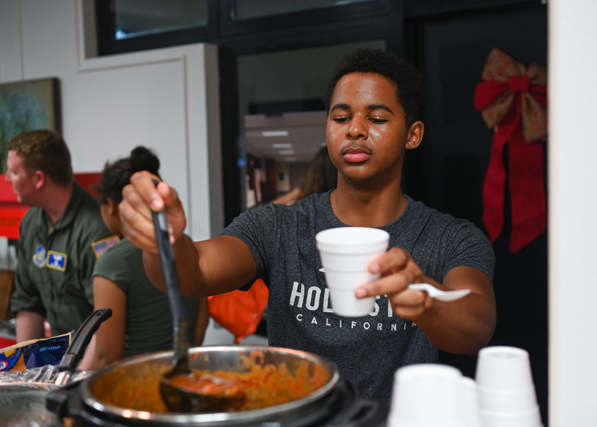 A U.S. Air Force Airman assigned to Andersen Air Force Base, Guam, gets a scoop of chili during a chili cook off at an opening ceremony of an Airmen’s Center at Chapel 1, Andersen Air Force Base, Guam, Dec. 15, 2021. Members from the chapel team and dorm residents worked for months reconstructing an empty space to operationalize a piece of the chapel to be Airmen focused. (U.S. Air Force photo by Senior Airman Aubree Owens)