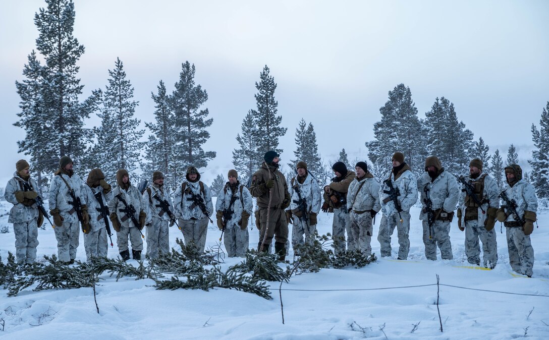A Norwegian soldier instructs U.S. Marines with 2d Marine Expeditionary Force on cold weather patrol measures using a snow table near Tolga, Norway, Dec. 5, 2021.