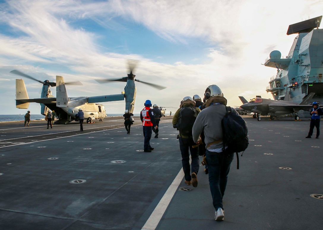 NATO Ambassadors and visitors load an MV-22 Osprey from Marine Medium Tiltrotor Squadron (VMM) 365 aboard Her Majesty's Ship Queen Elizabeth, Nov. 22, 2021. Visitors flew on U.S. Marine Corps MV-22 Ospreys from at Naval Air Station Sigonella to the ship off the coast of Italy where they observed U.K. and U.S. F-35 Lightning jets take off and land and toured the ship. (U.S. Marine Corps photo by Staff Sgt. Bryani Musick)