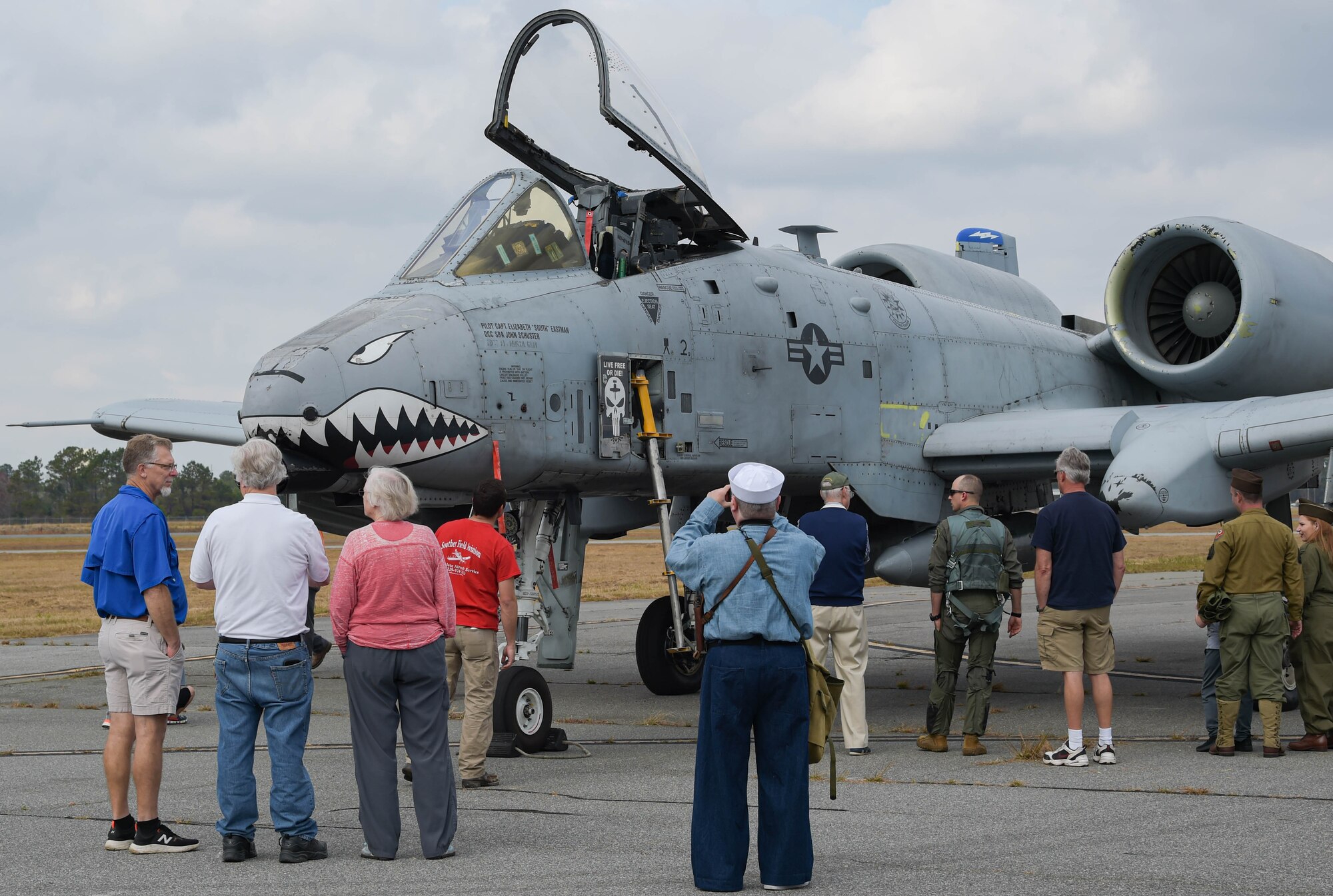 An A-10C Thunderbolt II aircraft is parked on the flight line at a WWII living history event at Douglas, Georgia, Dec. 4, 2021. Attendees take photos of the parked A-10C. The 63rd Flight Training Squadron was retired after WWII ended and has been maintained by volunteers; it is now known as the WWII Flight Training Museum. (U.S. Air Force photo by Senior Airman Rebeckah Medeiros)