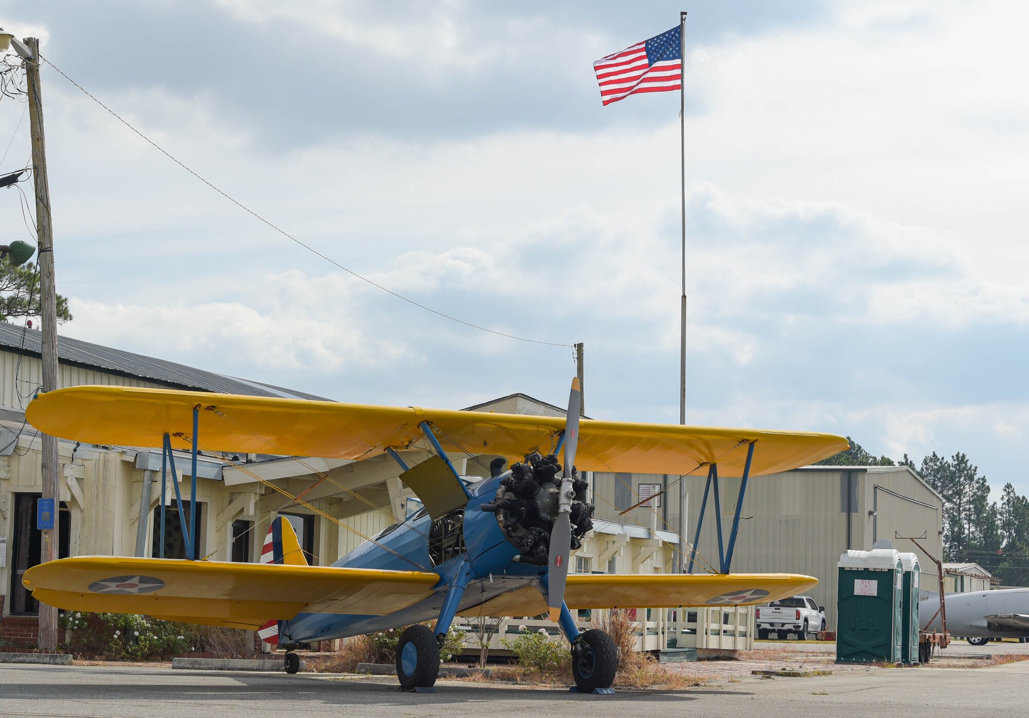 A restored WWII original PT-17 Stearman is parked on the flight line in front of a U.S. flag at Douglas, Georgia, Dec. 4, 2021. This aircraft was flown by retired 2nd Lt. Richard Piepenbring, grandfather of U.S. Air Force Maj. Will Piepenbring, 23rd Fighter Group assistant director of operations. People attending the WWII living history event had the chance to look at aircraft that were used in WWII. (U.S. Air Force photo by Senior Airman Rebeckah Medeiros)
