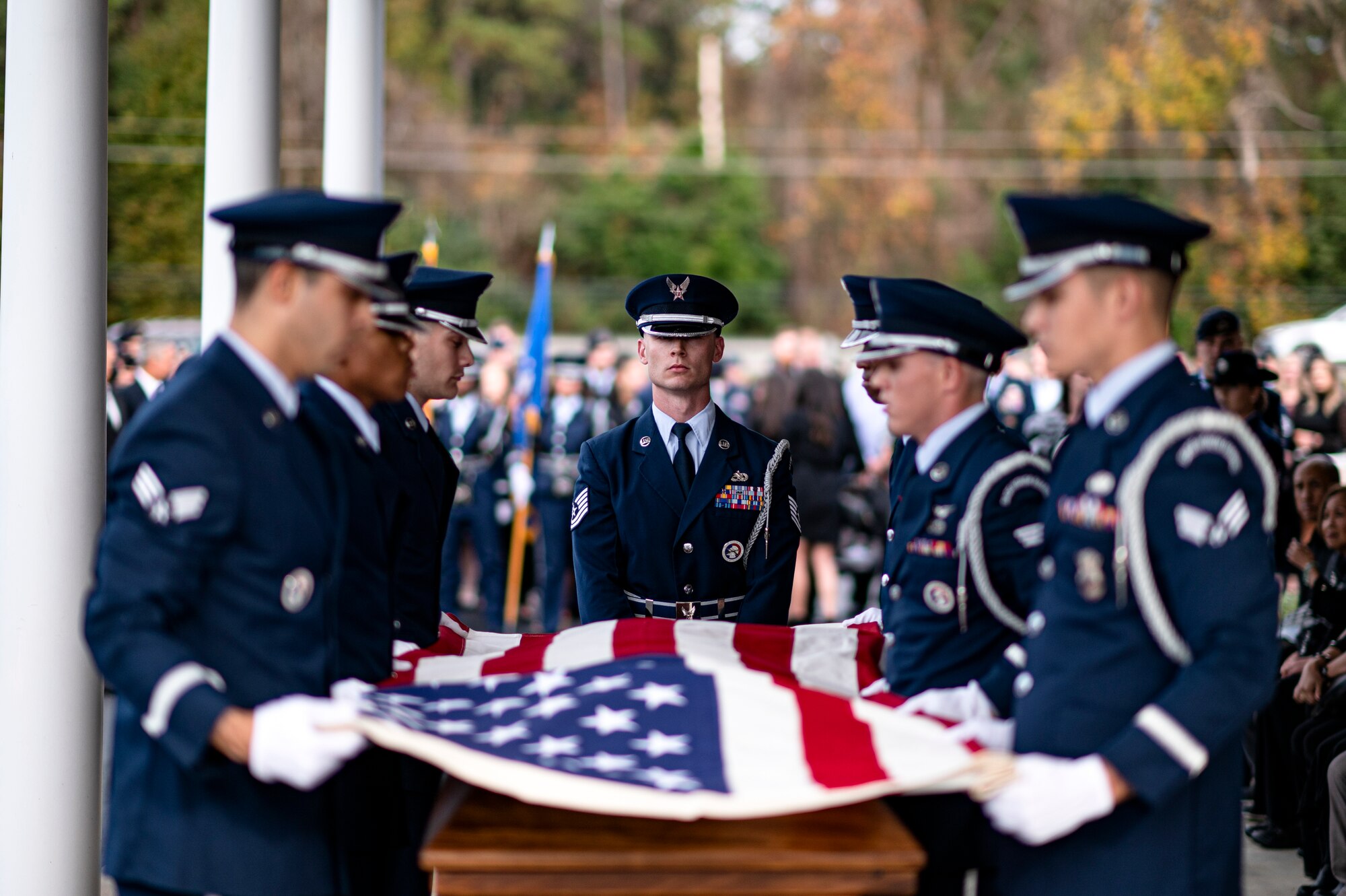 Photo of Airmen folding a flag over a casket