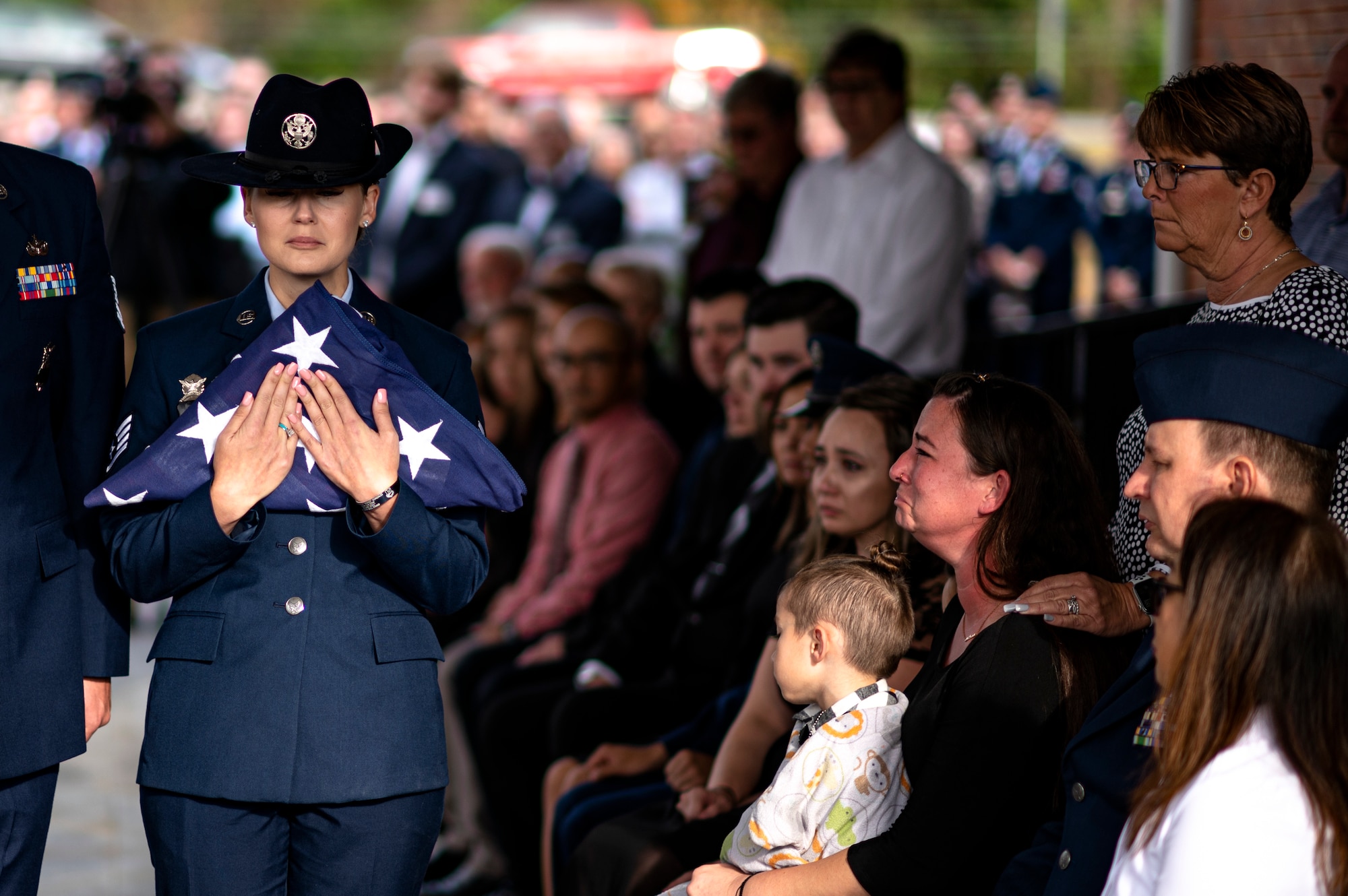 Photo of an Airman holding a folded flag