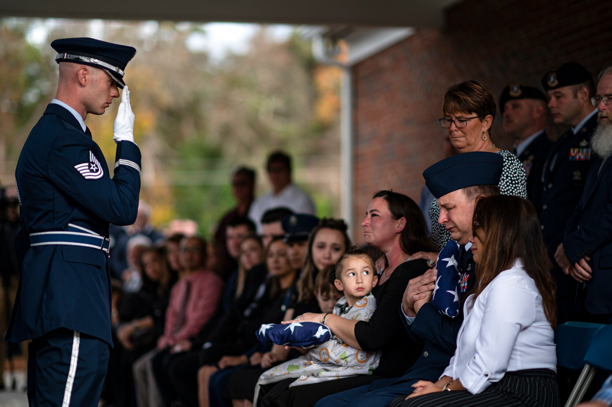 Photo of an Airman saluting a family