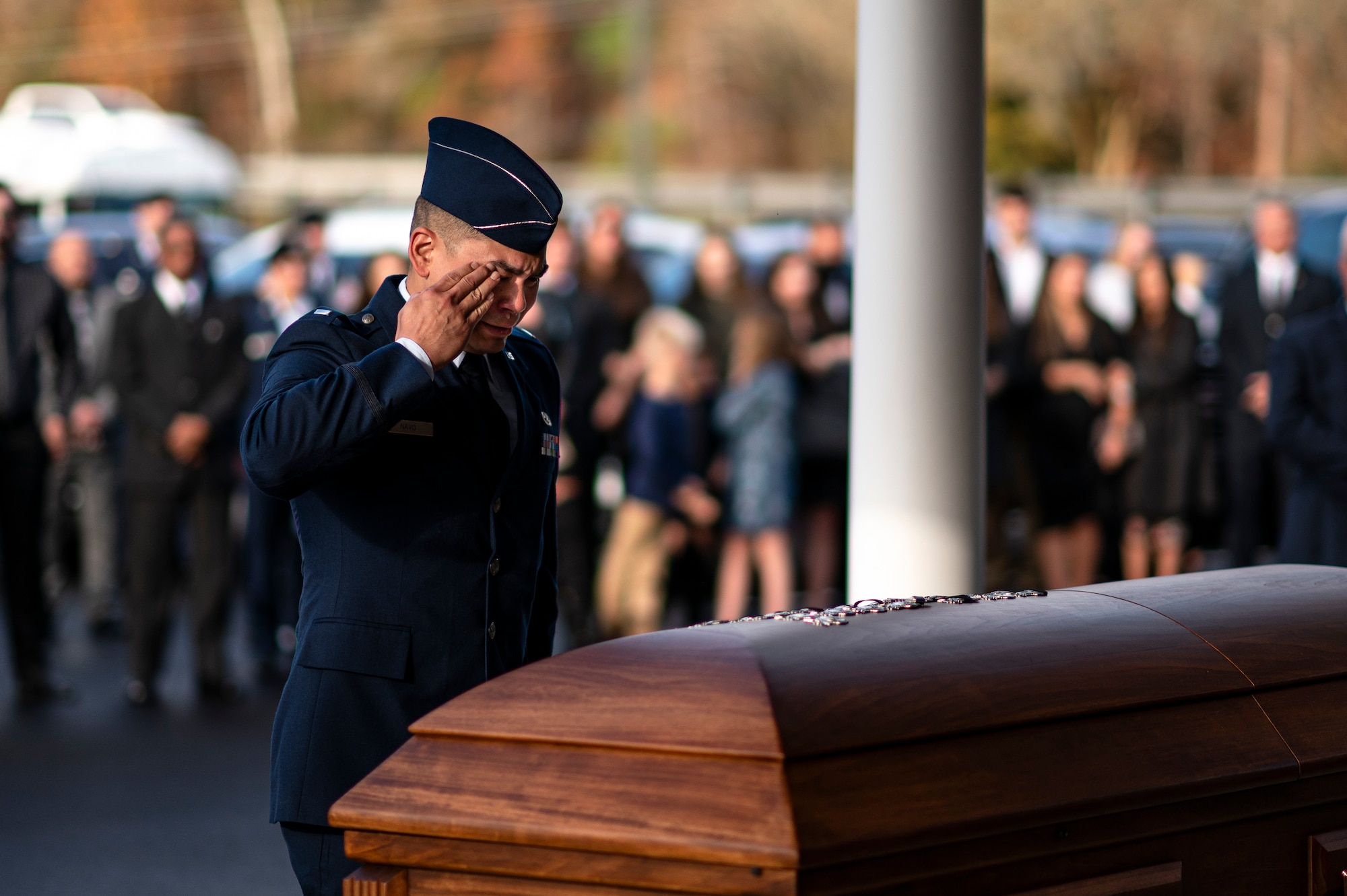 Photo of an Airman saluting a casket