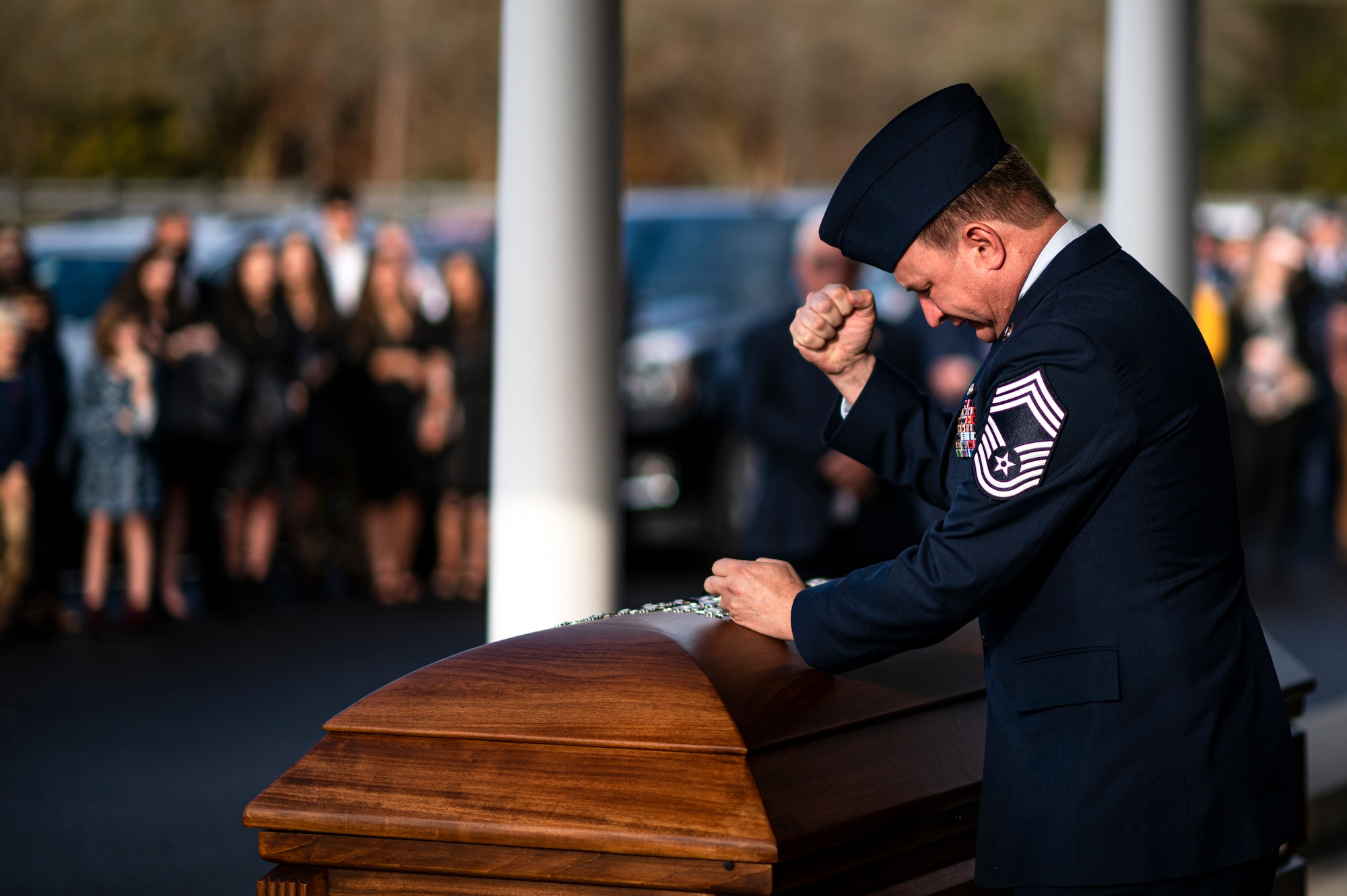 Photo of an Airman next to a casket