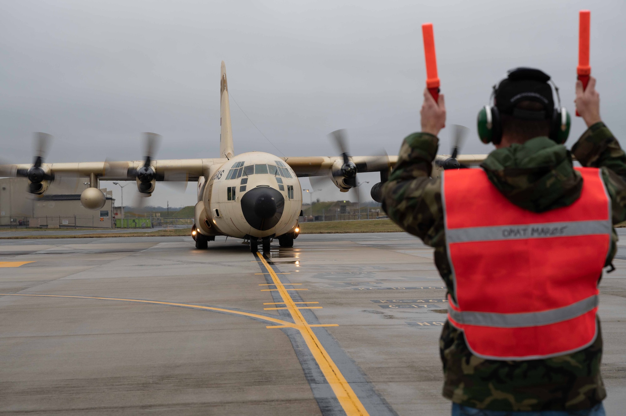 A member of the 436th Aircraft Maintenance Squadron transient alert marshals an Egyptian Air Force C-130 Hercules during a foreign military sales mission at Dover Air Force Base, Delaware, Dec. 11, 2021. The United States and Egypt share a strong partnership based on mutual interest in Middle East peace and stability, economic opportunity and regional security. Due to its strategic location, Dover AFB supports approximately $3.5 billion worth of foreign military sales annually. (U.S. Air Force photo by Senior Airman Faith Schaefer)