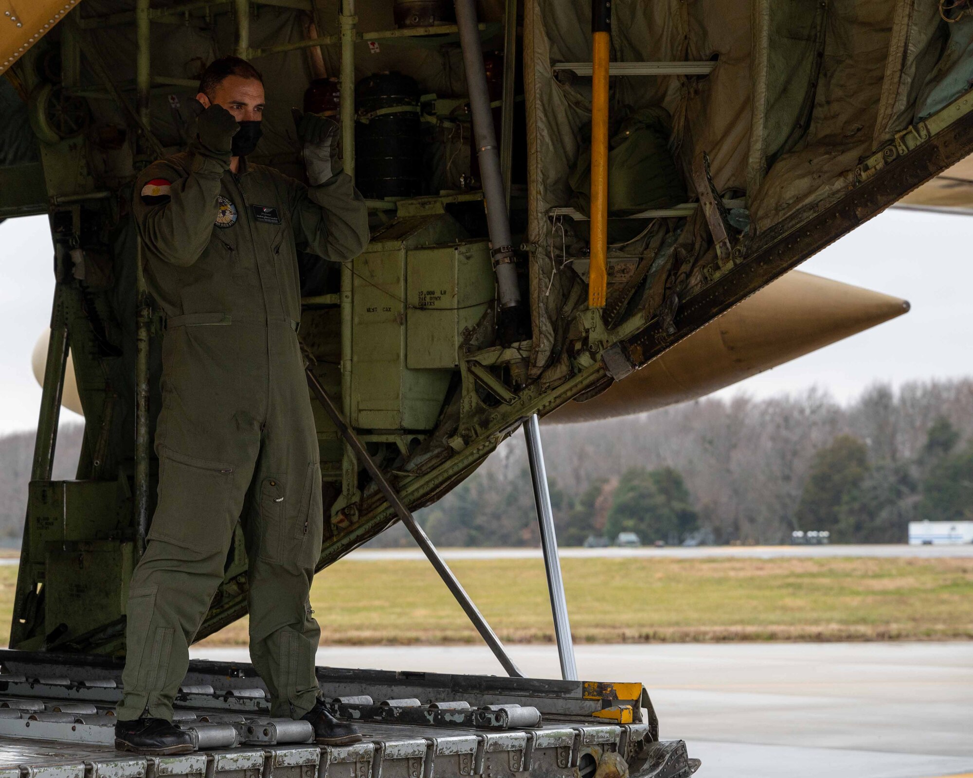 An Egyptian Air Force member marshals a K- loader to the ramp of an Egyptian Air Force C-130 Hercules during a foreign military sales mission at Dover Air Force, Delaware, Dec. 11, 2021. The United States and Egypt share a strong partnership based on mutual interest in Middle East peace and stability, economic opportunity and regional security. Due to its strategic location, Dover AFB supports approximately $3.5 billion worth of foreign military sales annually. (U.S. Air Force photo by Senior Airman Faith Schaefer)