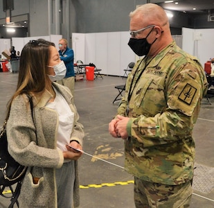 New York Army National Guard Col. Michael Bice speaks to Cassie Huang, 28, of New York after she received the 500,000th COVID-19 vaccination administered at the New York state vaccination site at the Jacob Javits Convention Center April 26, 2021. Bice, who directed the 620 National Guard troops and 400 civilians who worked at the site, has been recognized for his efforts by Crain’s New York Business and Empire Blue Cross Blue Shield.