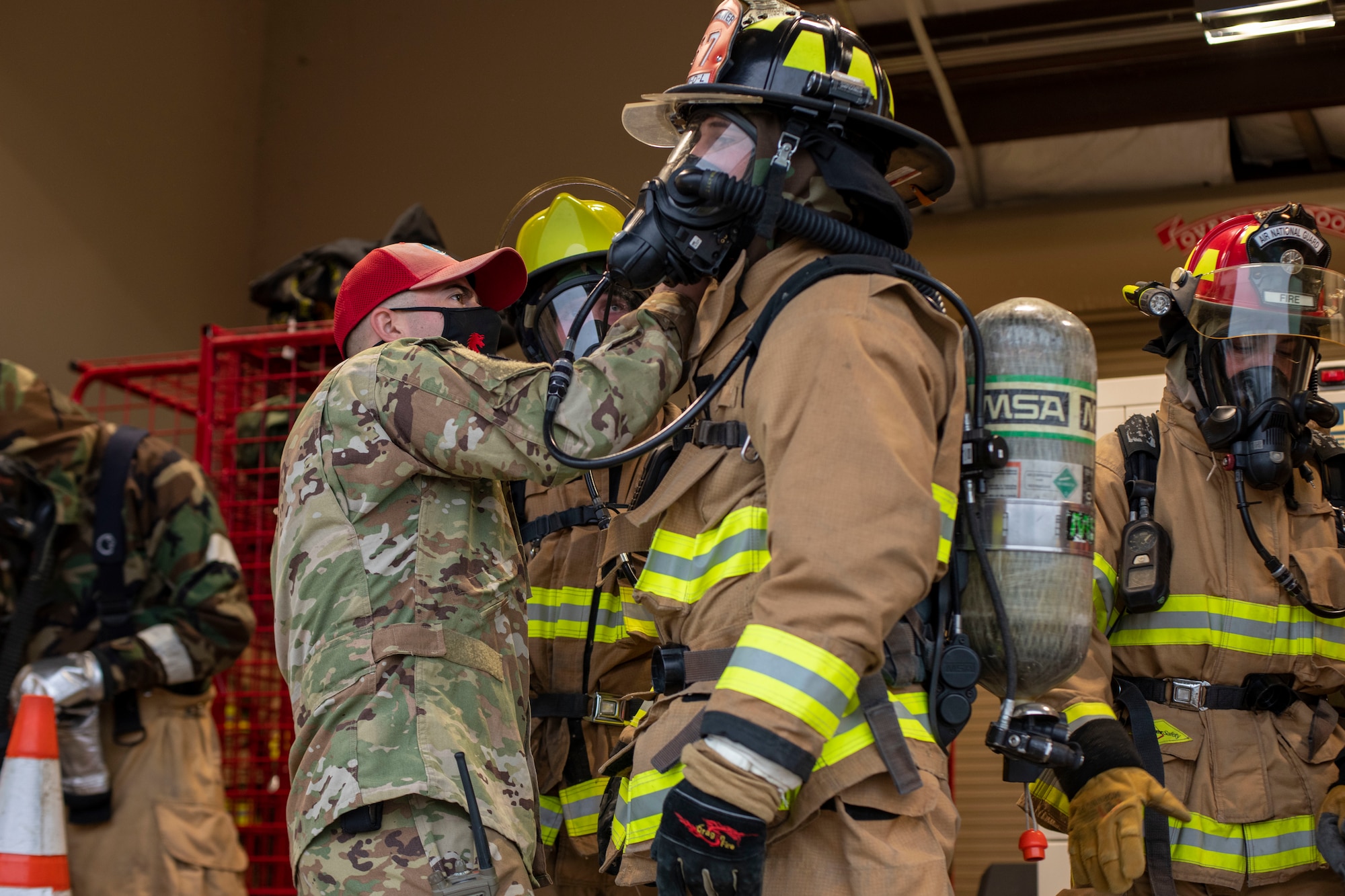 An instructor inspects a fireman's mask for any errors