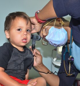 KINGS BAY, Ga. (July 12, 2021) - Andrea Thaxton, a pediatrician at Naval Branch Health Clinic Kings Bay, examines a two-year-old.  Thaxton holds a doctor of medicine degree from Wayne State University School of Medicine.  A native of Detroit, Michigan, she says, "As pediatricians, we are trained to meet the unique needs of children through all of their developmental stages, as they grow and mature."  (U.S. Navy photo by Deidre Smith, Naval Hospital Jacksonville/Released).