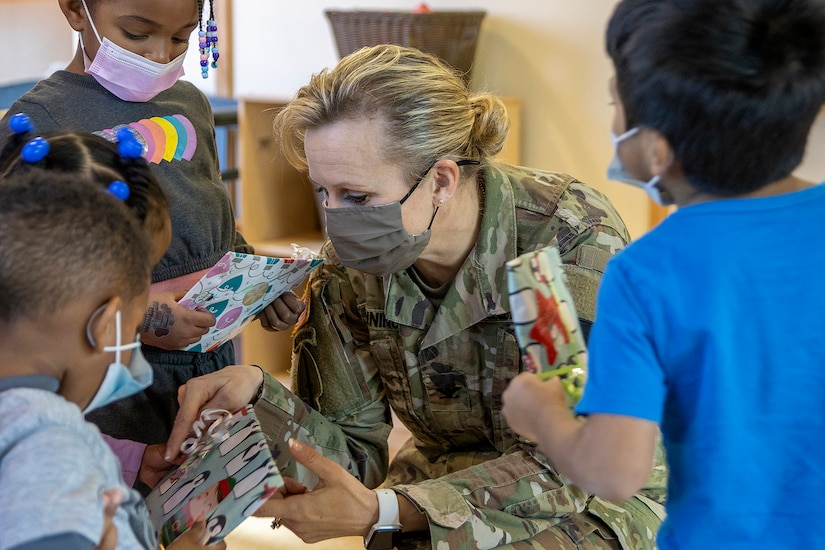 Col. Paige M. Jennings, U.S. Army Financial Management Command commander, talks with students at a local childcare center in Indianapolis Dec. 13, 2021. Jennings was joined by Barry W. Hoffman, USAFMCOM deputy to the commander; Command Sgt. Maj. Kenneth F. Law, USAFMCOM senior enlisted advisor; and Valerie Dillon, USAFMCOM secretary to the general staff, as they handed out special holiday presents to approximately 85 students. (U.S. Army photo by Mark R. W. Orders-Woempner)