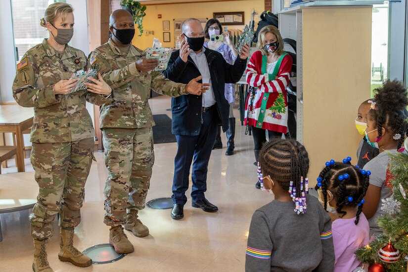Col. Paige M. Jennings, U.S. Army Financial Management Command commander; Command Sgt. Maj. Kenneth F. Law, USAFMCOM senior enlisted advisor; and Barry W. Hoffman, USAFMCOM deputy to the commander, lead students in singing Jingle Bells at a local childcare center in Indianapolis Dec. 13, 2021. Together, they handed out special holiday presents to approximately 85 students. (U.S. Army photo by Mark R. W. Orders-Woempner)