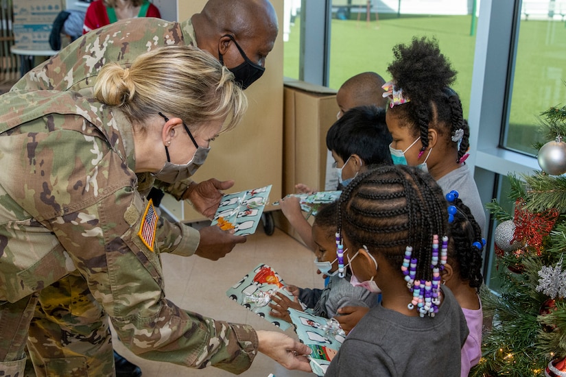Col. Paige M. Jennings, U.S. Army Financial Management Command commander, and Command Sgt. Maj. Kenneth F. Law, USAFMCOM senior enlisted advisor, hand out gifts at a local childcare center in Indianapolis Dec. 13, 2021. Together, the USAFMCOM leadership team handed out special holiday presents to approximately 85 students. (U.S. Army photo by Mark R. W. Orders-Woempner)