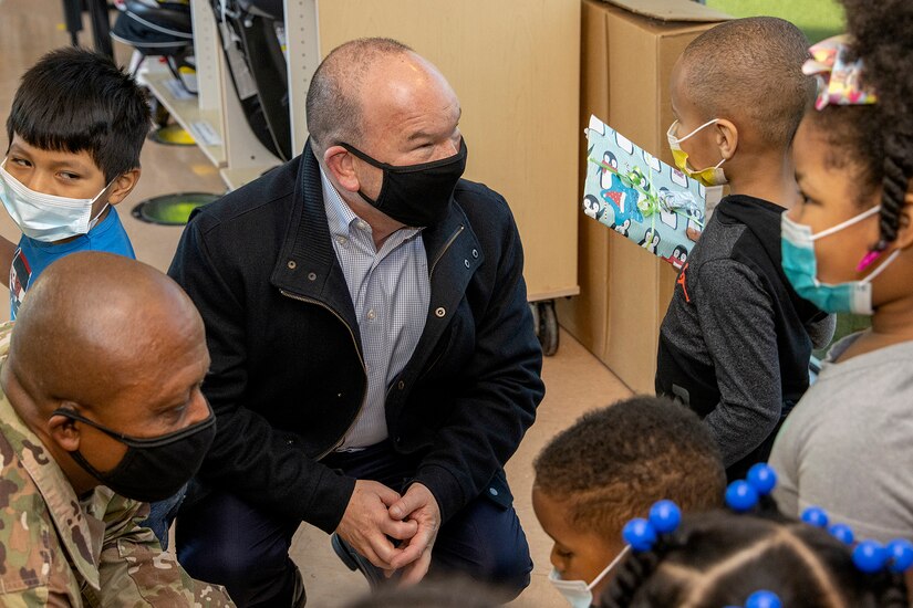 Barry W. Hoffman, U.S. Army Financial Management Command deputy to the commander, and Command Sgt. Maj. Kenneth F. Law, USAFMCOM senior enlisted advisor, talk with students at a local childcare center in Indianapolis Dec. 13, 2021. Together, the USAFMCOM leadership team handed out special holiday presents to approximately 85 students. (U.S. Army photo by Mark R. W. Orders-Woempner)