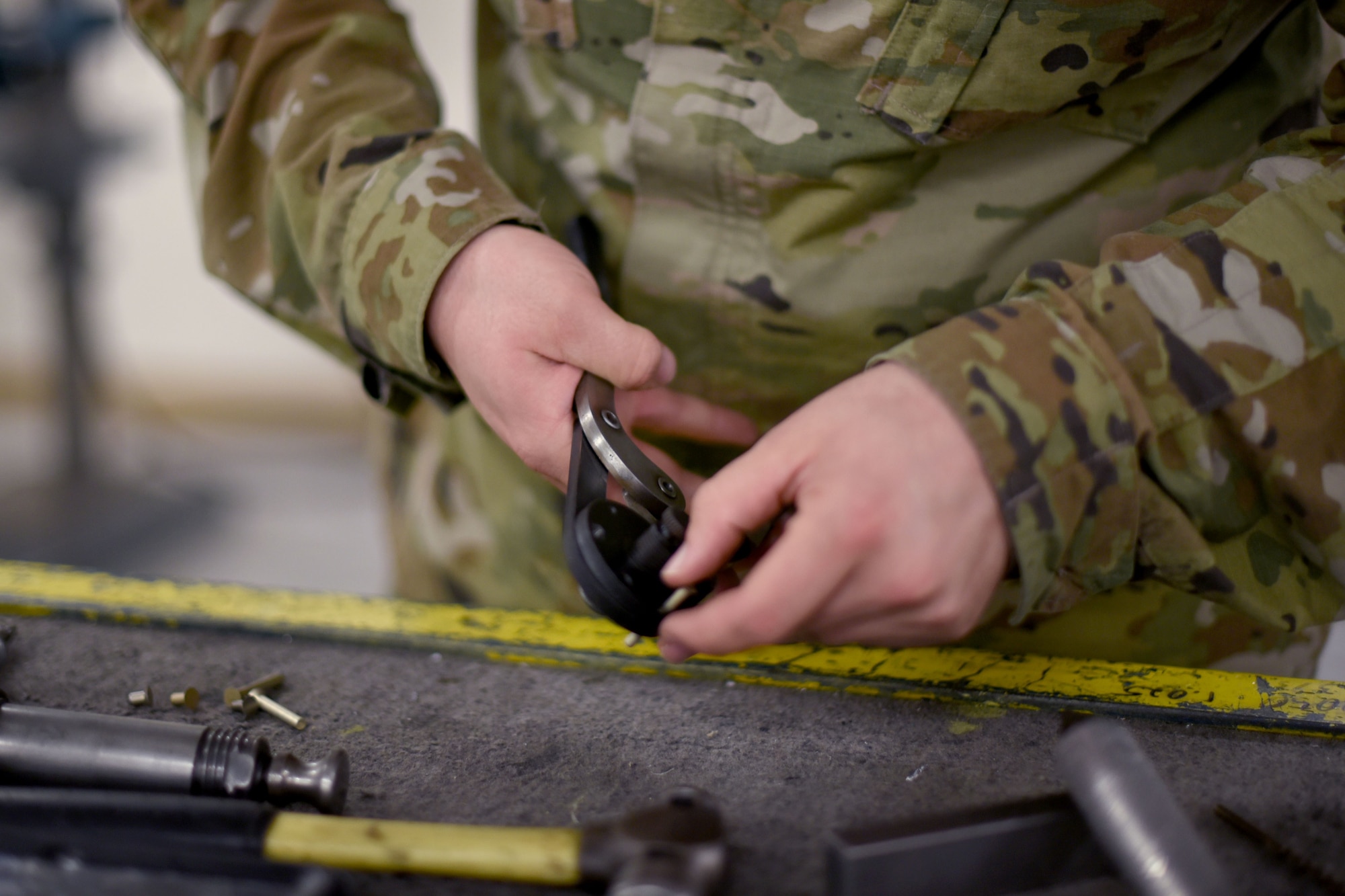 Senior Airman Jacob Adams, 24th Fighter Squadron Aircraft Structural Maintenance craftsman, cuts a rivet in the ASM shop at U.S. Naval Air Station Joint Reserve Base Fort Worth, Texas on Dec. 14, 2021. AMS Airmen fabricate custom parts to meet the unique demands of military aircraft. (U.S. Air Force photo by Staff Sgt. Randall Moose)