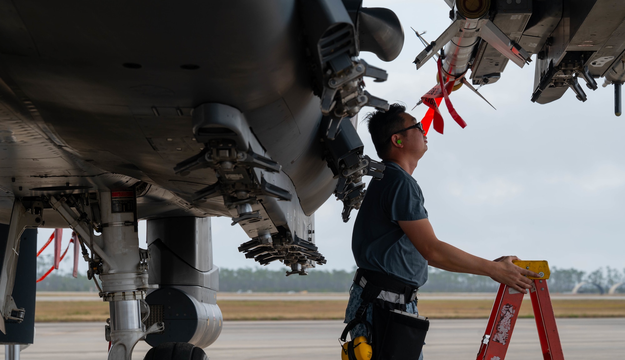 An airman performs an inspection on an aircraft